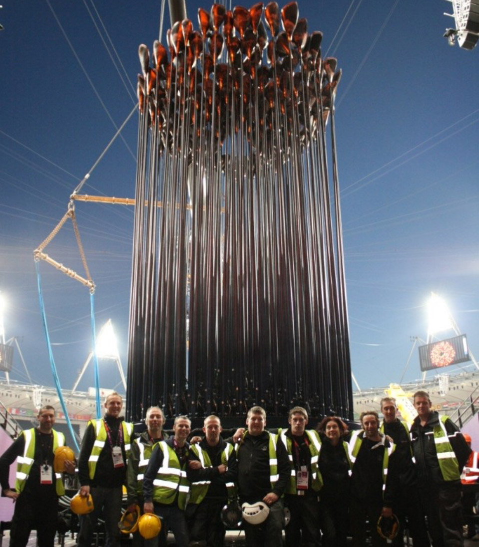 Group of engineers standing infront of an electrical display used in the olympic games